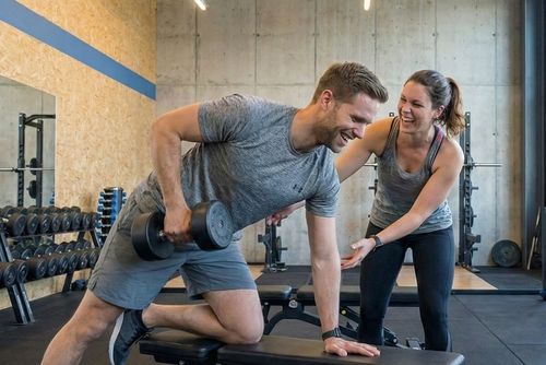 Mitglied und Trainerin bei einer Kraft-Übung mit einer Kurzhantel im N1 Cumminity Gym in Hassloch